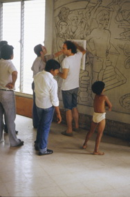 1982 El arquitecto italiano Clementino Sartori colaborando a las clases didacticos-productivas frente al mural de Luis Alfonso Velasquez