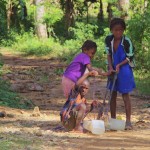 I bambini alla fonte per prendere l'acqua